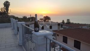 due bicchieri di vino su un balcone con vista sul tramonto di Appartamenti Borgo Panoramico n.1 a Tropea