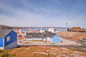 a small town with blue buildings on a hill at Nattoralik in Aasiaat