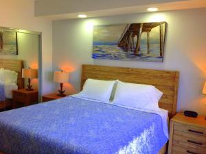 a bedroom with a bed with a blue comforter at Vistalmar Beach Resort in Deerfield Beach +129 photos