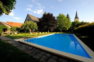 a swimming pool in the yard of a house at Gasthof Hotel Moser in Guttaring