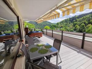 Cette chambre dispose d'un balcon avec une table et des chaises. dans l'établissement Wellness FeWo Szymecki, à Schönau im Schwarzwald