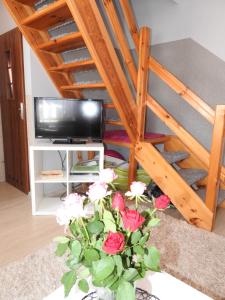 a vase of flowers in a room with a tv at Domki U Skrzata in Łeba