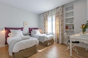 A bed or beds in a room at Plaza de España Deluxe Suites by Valcambre