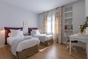 A bed or beds in a room at Plaza de España Deluxe Suites by Valcambre