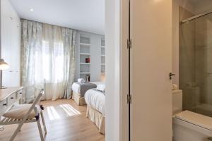 A bed or beds in a room at Plaza de España Deluxe Suites by Valcambre