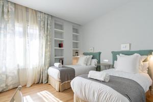 A bed or beds in a room at Plaza de España Deluxe Suites by Valcambre