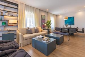 Plaza de España Deluxe Suites في إشبيلية: غرفة معيشة مع أريكة وطاولة
