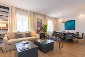 a living room with a couch and a dining room at Plaza de España Deluxe Suites in Seville