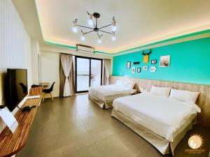 een hotelkamer met 2 bedden en een groene muur bij Ta Lang Guan Hai Mei Su B&B in Magong