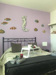1 dormitorio con 1 cama con caballos de mar en la pared en La Sirenetta, en Passoscuro