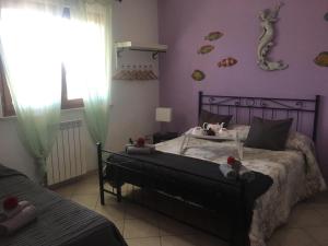 1 dormitorio con cama y pared púrpura en La Sirenetta, en Passoscuro