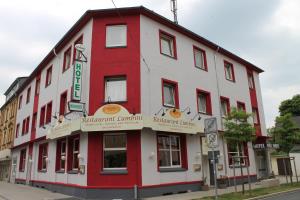 un edificio rojo y blanco en la esquina de una calle en Hotel Hubbert, en Castrop-Rauxel