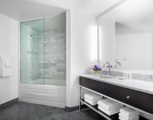 uma casa de banho com uma banheira, um lavatório e um chuveiro em AKA Beverly Hills em Los Angeles