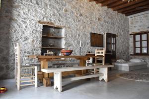 a wooden table in a room with a stone wall at Latmos 1860 in Skala