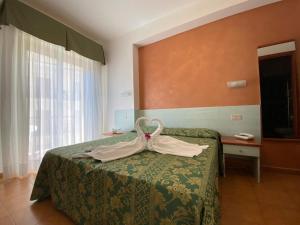 a hotel room with a bed and a desk at Hotel Soleado in Taormina