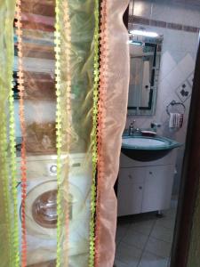 a bathroom with a toilet in a plastic shower curtain at DOWN TOWN LUXURY Apartment in Sarandë +12 photos