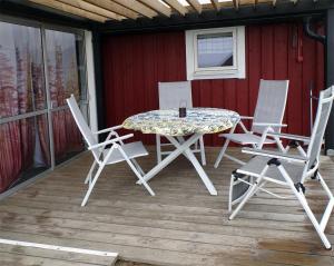 a patio table and chairs on a deck at 1C, Första parkett, 50m till badstrand in Byxelkrok +25 photos