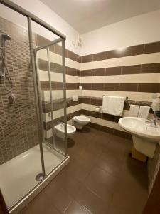 a bathroom with a shower, toilet and sink at Hotel Soleado in Taormina