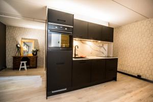 uma cozinha com um grande frigorífico preto num quarto em appartement - sauna - natuur - Utrecht em Soest