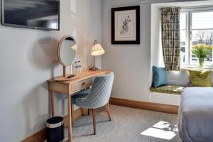 a bedroom with a desk with a mirror and a bed at Barn Owl Inn in Newton Abbot