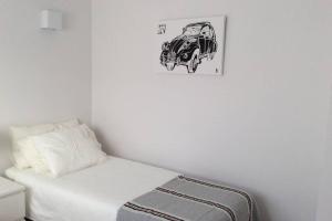 ein Bett mit einer Zeichnung eines Autos an der Wand in der Unterkunft Chalet pareado a 5 minutos andando de la playa in La Garita