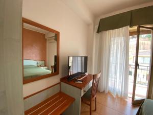 a room with a desk, chair and a window at Hotel Soleado in Taormina