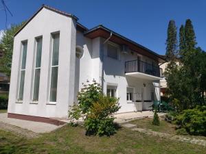 Cette maison blanche dispose d'une terrasse couverte et d'un balcon. dans l'établissement Ilona Apartmanház, à Siófok