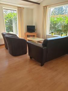 sala de estar con mesa y sillas de cuero negro en De Kleine Kriemelkuil, en Ermelo