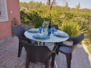 a white table with chairs and a bottle of wine at Lagoon Beach House in Nea Potidaea