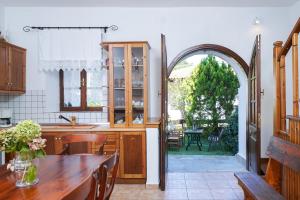 an open kitchen with a table and an archway at Villa Nina in Panayia