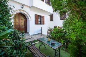 a table and bench in front of a house at Villa Nina in Panagia