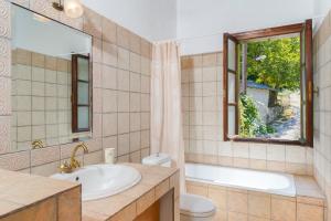 a bathroom with a sink and a toilet and a window at Villa Nina in Panagia +14 photos