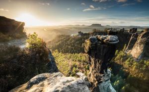 a person standing on the edge of a cliff overlooking a valley at Gästehaus Schrot in Bad Schandau