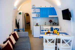 uma cozinha com uma mesa e uma cozinha com uma cozinha em Bonita Santorini Cave em Éxo Goniá