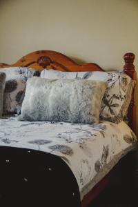 - un lit avec une tête de lit en bois et des oreillers dans l'établissement corby house, à Ardara