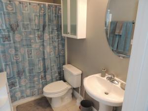 a bathroom with a toilet and a sink and a mirror at Beach Vacation Condos in Myrtle Beach