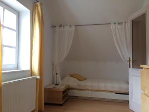 ein weißes Schlafzimmer mit einem Bett und einem Fenster in der Unterkunft ALPHA in Badacsonytördemic