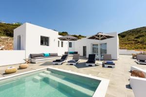 a patio with a pool and chairs and a house at PAROS VILLA BLUE SENSES in Aliki