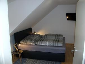 uma cama com duas almofadas num quarto em up Stuuv em Greetsiel