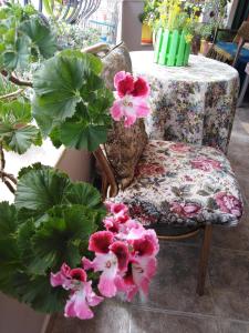 a chair with a floral seat and a table with flowers at DOWN TOWN LUXURY Apartment in Sarandë