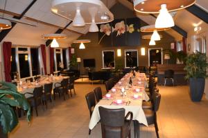 une salle à manger avec de longues tables et chaises dans l'établissement Vakantiehuis De Binnenplaets, à Elsloo