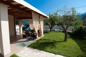 a covered patio with a table and a tree at B&B Alle Tre Rose in Montignoso