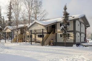 a house with snow on the ground in front of it at Chena Hot Springs Resort in Chena Hot Springs