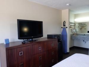 1 dormitorio con TV en la parte superior de una cómoda de madera en DEERFIELD INN, en Parsons