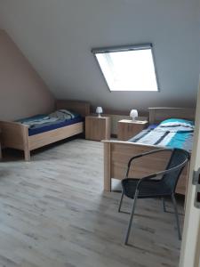 a bedroom with two beds and a desk and a window at Auf dem Lande in Weener