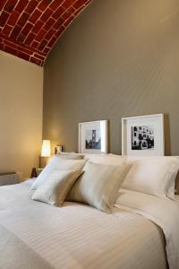 een groot wit bed met twee foto's aan de muur bij Albergo D'italia in Chivasso