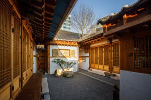 einen Innenhof mit Holzhäusern und einem Baum in der Mitte in der Unterkunft GaEunChae in Jeonju