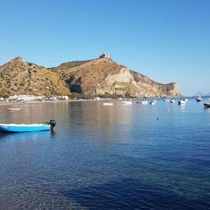 a blue boat sitting in the water near a beach at B&B La Casa Du Barone in Falcone