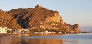 a beach with a hill with a house on top of it at B&B La Casa Du Barone in Falcone