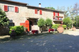 a house with red shutters and chairs in front of it at Agriturismo La Selva in Siena